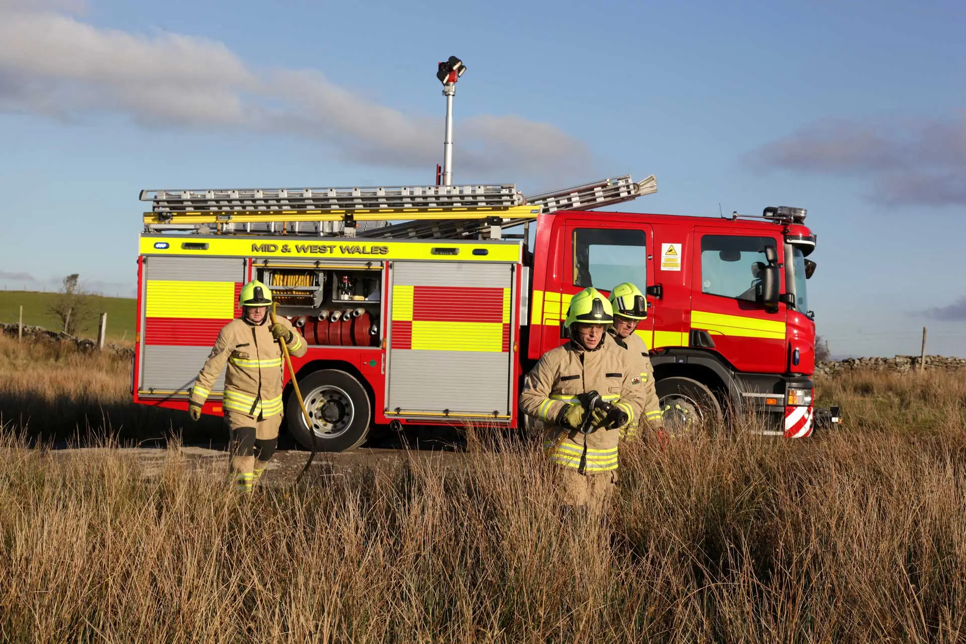 fire fighters and fire truck in field